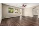 Spacious living room with dark wood floors, modern ceiling fan, and natural light from large windows at 7220 W Ashby Dr, Peoria, AZ 85383