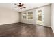 Bright living area featuring a ceiling fan, wood-look floors, and a door leading to the backyard at 7220 W Ashby Dr, Peoria, AZ 85383