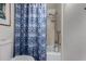 Cozy bathroom featuring a shower and bathtub combination with a patterned blue and white shower curtain at 7604 N 46Th Ave, Glendale, AZ 85301