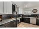 Modern kitchen boasts stainless steel appliances, granite countertops, and stylish black and white cabinetry at 7604 N 46Th Ave, Glendale, AZ 85301