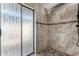 Walk-in shower with decorative door and attractive stone-look tile at 7604 N 46Th Ave, Glendale, AZ 85301
