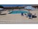 Community pool with lounge chairs, tables, and blue/white umbrellas at 7750 E Broadway Rd # 604, Mesa, AZ 85208
