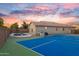Beautiful backyard featuring a swimming pool, tennis court, and well-maintained landscaping at 7838 N 110 Ln, Glendale, AZ 85307