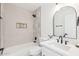 Clean bathroom showcasing a bathtub and shower combo with modern fixtures and a white vanity at 7838 N 110 Ln, Glendale, AZ 85307