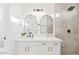 Elegant bathroom features a double vanity with modern fixtures, arched mirrors, and a walk-in shower with tile surround at 7838 N 110 Ln, Glendale, AZ 85307
