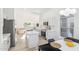 Well-lit open kitchen with white cabinetry, stainless steel appliances, a center island, and a dining area at 7838 N 110 Ln, Glendale, AZ 85307