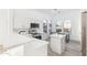Modern kitchen with white cabinets, stainless steel appliances, quartz countertops, and an adjacent dining area with arched windows at 7838 N 110 Ln, Glendale, AZ 85307