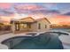 Inviting backyard with a refreshing pool, covered patio, and a tennis court under a vibrant sunset at 7838 N 110 Ln, Glendale, AZ 85307
