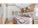 Bright bedroom with wood-look floors, window, quilt bed, and overhead storage at 786 Cinnabar Dr, Apache Junction, AZ 85119
