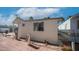 Cozy mobile home with brick patio, neutral siding, and well-maintained landscaping under a bright, partly cloudy sky at 786 Cinnabar Dr, Apache Junction, AZ 85119