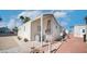 Charming mobile home with white gravel, desert landscaping, and sturdy ladder on the brick-lined patio at 786 Cinnabar Dr, Apache Junction, AZ 85119