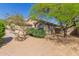View of the rear exterior of the home with desert landscaping and mature trees providing shade and privacy at 10431 E Morning Star Dr, Scottsdale, AZ 85255