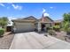 Charming single-story home featuring a two-car garage, desert landscaping, and an American flag at 1081 W Stephanie Ln, San Tan Valley, AZ 85143
