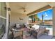 Cozy outdoor patio area with comfortable wicker seating, colorful rug, and ceiling fan overlooking the pool at 1081 W Stephanie Ln, San Tan Valley, AZ 85143
