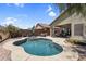 Beautiful backyard pool with mature landscaping, relaxing seating area, and a covered patio at 1081 W Stephanie Ln, San Tan Valley, AZ 85143