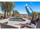 Lovely backyard pool with mature trees, desert landscaping, and a shaded seating area at 1081 W Stephanie Ln, San Tan Valley, AZ 85143