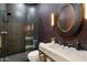 Modern bathroom with black tile shower, marble vanity, and unique round mirror at 11143 E Onyx Ct, Scottsdale, AZ 85259