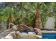 A rock waterfall feature spills into a hot tub alongside a swimming pool at 11143 E Onyx Ct, Scottsdale, AZ 85259