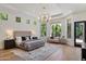 Bright and airy main bedroom with hardwood floors, statement chandelier and views of the lush backyard at 11143 E Onyx Ct, Scottsdale, AZ 85259