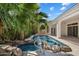 Beautiful pool with spa, rock features, and lush tropical landscaping at 11143 E Onyx Ct, Scottsdale, AZ 85259