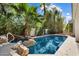 Stunning backyard pool with rock waterfall feature and lush landscaping at 11143 E Onyx Ct, Scottsdale, AZ 85259