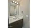 Well lit bathroom with a modern vanity, white countertop, and large mirror at 11216 W Apache St, Avondale, AZ 85323
