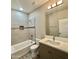 Bright bathroom featuring a tub with tile surround and modern vanity with solid surface countertop at 11216 W Apache St, Avondale, AZ 85323