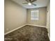 A bedroom with neutral walls, carpet, and a window at 11216 W Apache St, Avondale, AZ 85323