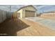 Rear view of a well-maintained single-story home with a neutral color palette, a two-car garage and block fencing at 11216 W Apache St, Avondale, AZ 85323