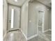 Modern hallway with a brightly lit white front door and access to the laundry room at 11216 W Apache St, Avondale, AZ 85323
