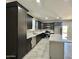 Well-lit kitchen with an island, modern appliances, sleek cabinetry, and tile flooring throughout the house at 11216 W Apache St, Avondale, AZ 85323