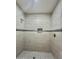 Shower stall featuring gray tiling with a built-in niche, along with a shower head at 11216 W Apache St, Avondale, AZ 85323