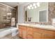 Bathroom with double sinks, updated lighting, and a shower with glass doors and tile surround at 1245 E Emile Zola Ave, Phoenix, AZ 85022
