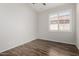 Clean bedroom featuring wood-look tile, a window with white shutters, and neutral walls at 1245 E Emile Zola Ave, Phoenix, AZ 85022