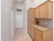 Hallway with light-colored tile, light-colored cabinets, and granite countertops at 1245 E Emile Zola Ave, Phoenix, AZ 85022