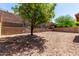 An expansive backyard featuring beautiful landscaping, a retaining wall, and rock ground cover at 12838 W Desert Mirage Dr, Peoria, AZ 85383