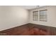Bedroom with wood flooring, two windows, and neutral color palette at 12838 W Desert Mirage Dr, Peoria, AZ 85383