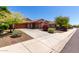 Attractive single-story home featuring a tidy front yard, a two-car garage, and mature trees at 12838 W Desert Mirage Dr, Peoria, AZ 85383