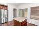 Eat-in kitchen with stainless steel refrigerator, island, wood cabinets, and patio access at 12838 W Desert Mirage Dr, Peoria, AZ 85383