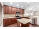 Kitchen with stainless appliances, central island, and wood cabinets with stone countertops at 12838 W Desert Mirage Dr, Peoria, AZ 85383