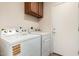 This laundry room features a washer and dryer with cabinets at 12838 W Desert Mirage Dr, Peoria, AZ 85383