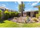 Backyard landscape design featuring rock beds, accent lighting, gravel pathway and lush bushes at 1329 E Catalina Dr, Phoenix, AZ 85014
