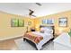 Bright bedroom featuring a modern ceiling fan, guitar, and windows overlooking the yard at 1329 E Catalina Dr, Phoenix, AZ 85014
