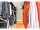 Walk-in closet with orange accent wall and modern shelving at 1329 E Catalina Dr, Phoenix, AZ 85014