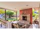 Inviting covered patio with a stone fireplace and lush green view at 1329 E Catalina Dr, Phoenix, AZ 85014