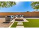 Outdoor living space featuring a fire pit with seating and artificial turf at 14107 W Christy Dr, Surprise, AZ 85379