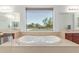 Bright bathroom with a soaking tub and large window overlooking the backyard at 14107 W Christy Dr, Surprise, AZ 85379