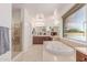Spacious bathroom featuring a soaking tub, shower, and dual sink vanities at 14107 W Christy Dr, Surprise, AZ 85379