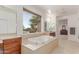 Bright bathroom features a soaking tub beneath a window and dual sink vanities at 14107 W Christy Dr, Surprise, AZ 85379