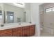 Bathroom featuring wood cabinets, a white countertop, and a separate shower area for a functional design at 14107 W Christy Dr, Surprise, AZ 85379